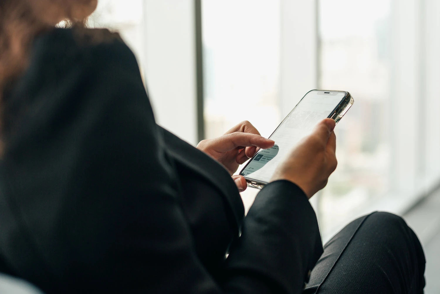 Person holding a smartphone, checking social media with a blurred background