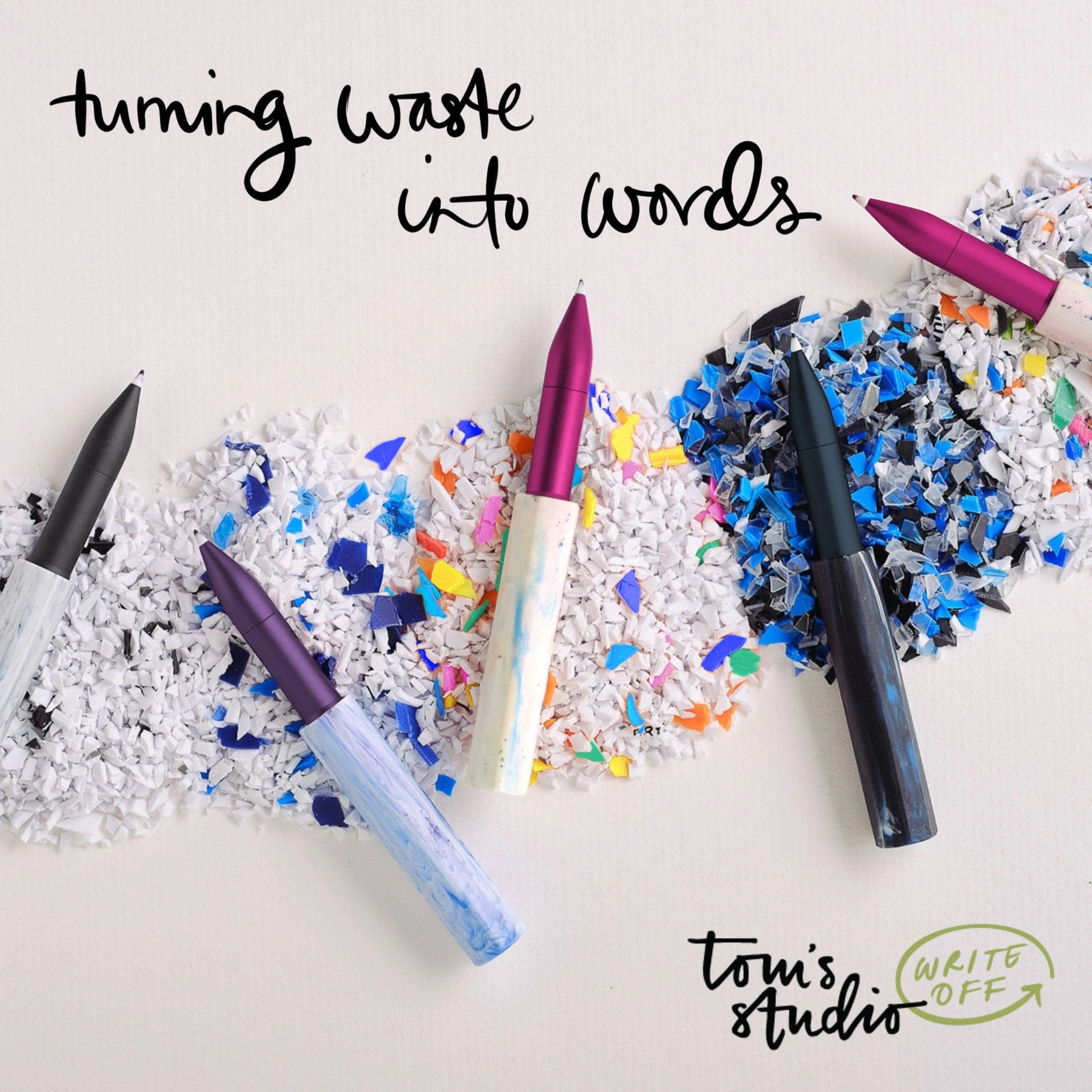 Wren write off pens on a bed of shredded plastic pens which will be recycled to make more pens. Winner of the Best Sustainable Product Stationery Awards 2026. Tom's Studio. Turning Waste into Words.